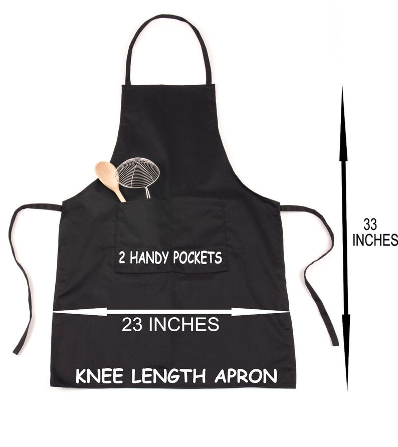 Puede incluir: Delantal negro de largo hasta la rodilla con dos bolsillos y el texto "2 Handy Pockets" y "23 pulgadas" impreso en la parte delantera. El delantal mide 84 cm de largo.