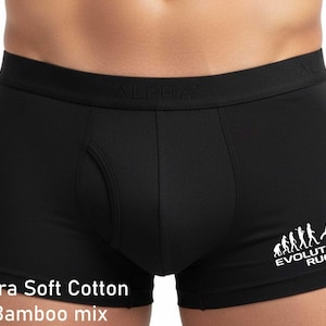 May include: Black boxer briefs featuring an elastic waistband with the word ALPHA embossed. The right leg displays a white graphic showing the evolution of rugby and the text EVOLUTION RUGBY. The bottom left corner includes the text Ultra Soft Cotton Bamboo mix.