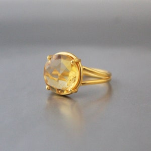K&ouml;nnte beinhalten: Ein goldener Ring mit einem gro&szlig;en, ovalen, hellgelben Edelstein.