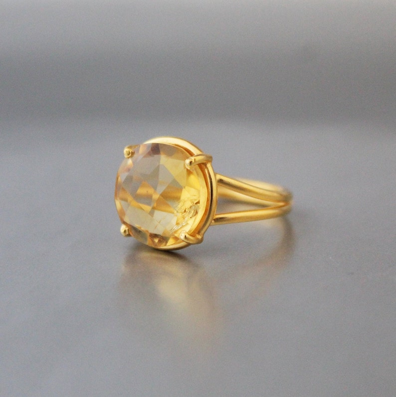 K&ouml;nnte beinhalten: Ein goldener Ring mit einem gro&szlig;en, ovalen, hellgelben Edelstein.