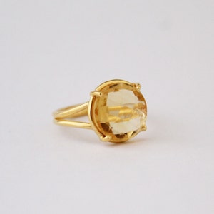 K&ouml;nnte beinhalten: Ein goldener Ring mit einem gro&szlig;en, ovalen, hellgelben Edelstein.