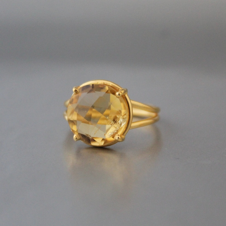 K&ouml;nnte beinhalten: Ein goldener Ring mit einem gro&szlig;en, runden, facettierten Topas-Edelstein.