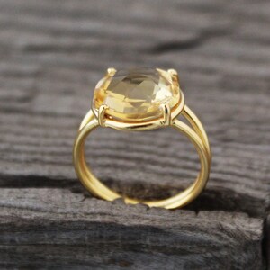K&ouml;nnte beinhalten: Ein goldener Ring mit einem gro&szlig;en, ovalen, hellgelben Edelstein.