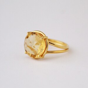 K&ouml;nnte beinhalten: Ein goldener Ring mit einem gro&szlig;en, facettierten, gelben Topas-Edelstein.