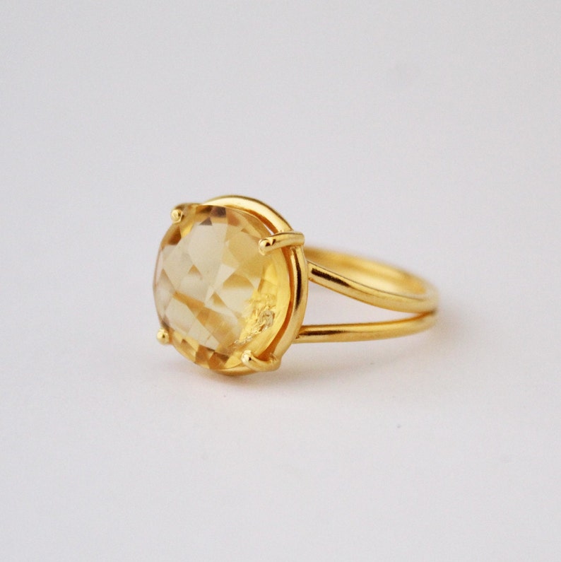 K&ouml;nnte beinhalten: Ein goldener Ring mit einem gro&szlig;en, facettierten, gelben Topas-Edelstein.