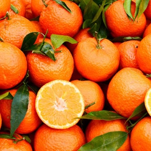 May include: A close-up of a pile of bright orange mandarins with green leaves. The mandarins are arranged in a random pattern, with some of them cut in half, revealing the juicy flesh.