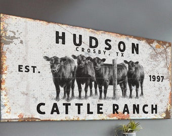 May include: Black and white sign with the text "HUDSON CROSBY, TX EST. 1997 CATTLE RANCH" and a drawing of four black cows standing behind a fence.