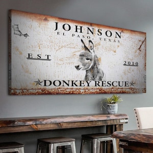 May include: Rustic metal sign with a donkey illustration and the text "JOHNSON EL PASO, TEXAS EST 2010 DONKEY RESCUE".