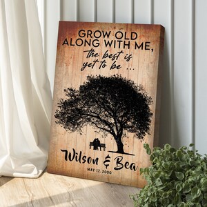 May include: A rustic wood-grain background with a black silhouette of a tree and two figures sitting on a bench. The text "GROW OLD ALONG WITH ME, The best is yet to be..." is above the tree. Below the tree is the text "Wilson & Bea MAY 17, 2000".