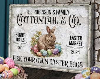 May include: A vintage-style sign with the text "The Robinson's Family Cottontail & Co. Bunny Trails Est. Easter Market 2024 Pick Your Own Easter Eggs". The sign features a brown bunny rabbit sitting on a bed of green grass and colorful Easter eggs.