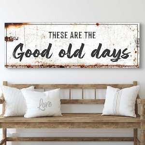 May include: A white metal sign with a distressed, rusty look. The sign reads "These are the good old days".
