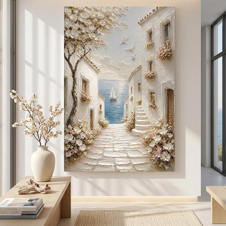 May include: A textured oil painting on canvas depicting a Mediterranean coastal scene with white stone buildings, a cobblestone path leading to a blue sea, a sailboat, and blooming flowers. The artwork features thick impasto brushstrokes.