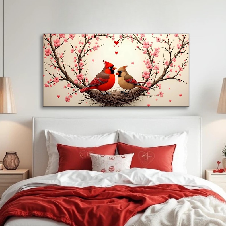 May include: Two red cardinals perched in a nest made of twigs, surrounded by a heart-shaped frame of blooming pink cherry blossoms. The birds are facing each other, with small red hearts floating above them.