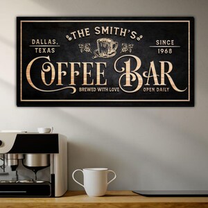 May include: A black and white sign with gold lettering that reads "The Smith's Coffee Bar" with the text "Dallas, Texas" and "Brewed with Love" in the top left corner and "Since 1968" and "Open Daily" in the top right corner.