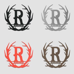 May include: Four metal wall decorations featuring a large letter "R" surrounded by a wreath of antlers. The name "Robinson" is written below the letter. The wreaths are in black, silver, red, and brown.