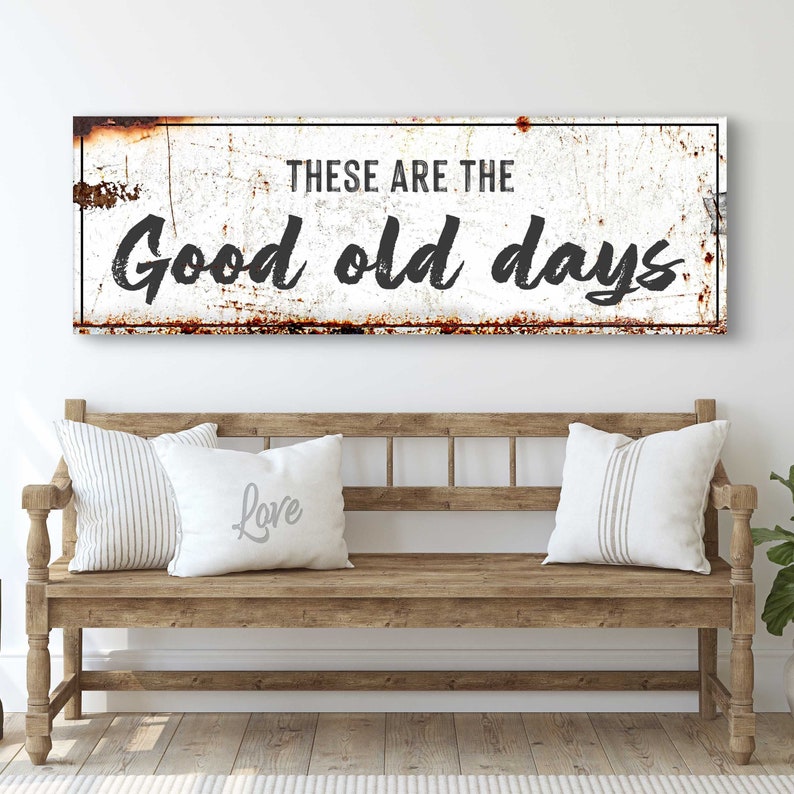 May include: A white metal sign with a distressed, rusty look. The sign reads "These are the good old days".
