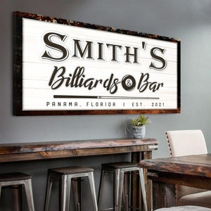 Puede incluir: Un letrero de madera blanco con texto marr&oacute;n que dice "Smith's Billiards & Bar" con un gr&aacute;fico de bola de billar y taco de billar. El letrero tambi&eacute;n incluye el texto "Panam&aacute;, Florida | Est. 2021".