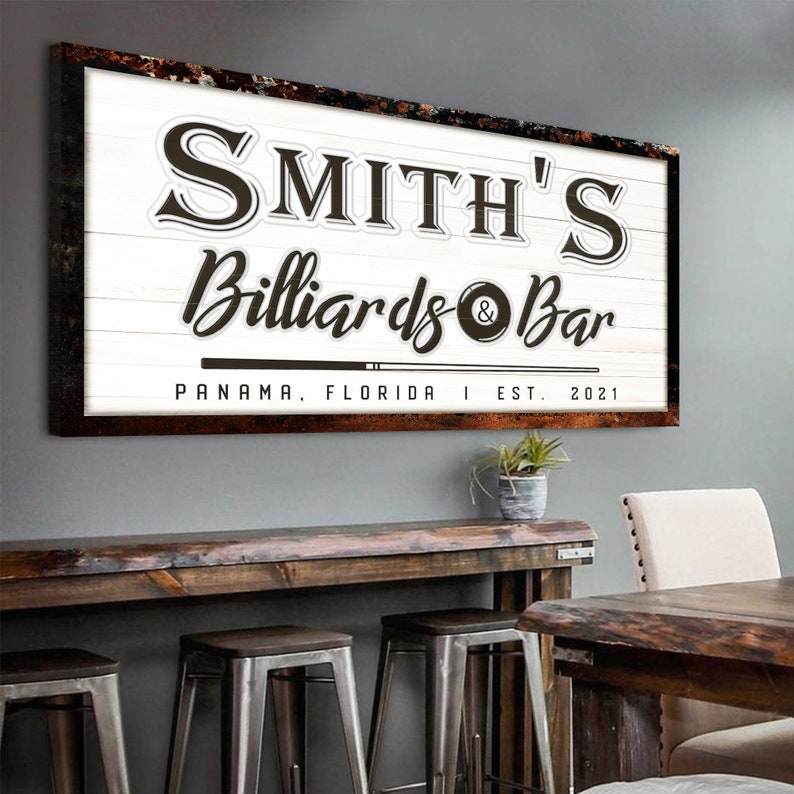 Puede incluir: Un letrero de madera blanco con texto marr&oacute;n que dice "Smith's Billiards & Bar" con un gr&aacute;fico de bola de billar y taco de billar. El letrero tambi&eacute;n incluye el texto "Panam&aacute;, Florida | Est. 2021".