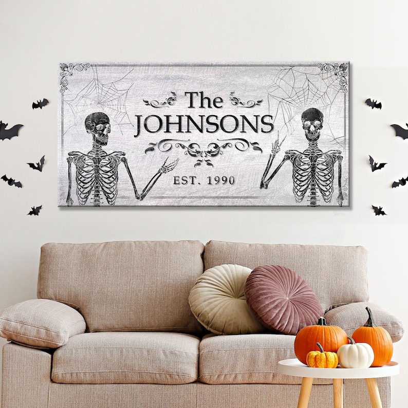 May include: A black and white Halloween-themed family name sign with two skeletons, a spiderweb design, and the text "The Johnsons Est. 1990".