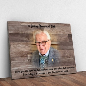 Puede incluir: Una impresi&oacute;n de lienzo de madera con una foto de un hombre mayor con gafas y un su&eacute;ter estampado. El texto "In Loving Memory of Dad" est&aacute; en la parte superior de la impresi&oacute;n. El texto "I know you still hear me dad, so please know this is true that everything I am today is all because of you. Forever in our hearts" est&aacute; en la parte inferior de la impresi&oacute;n.