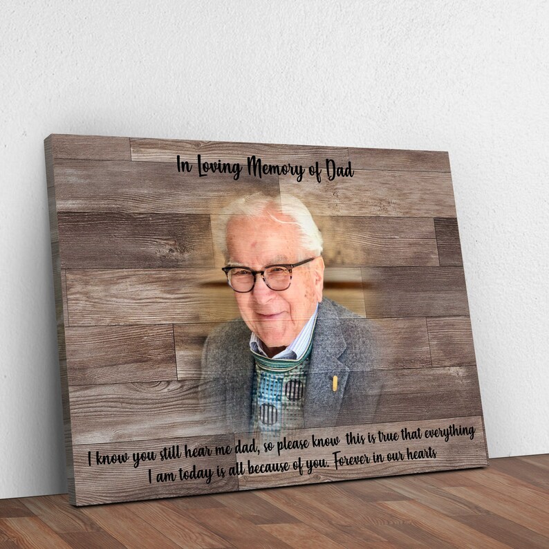 Puede incluir: Una impresi&oacute;n de lienzo de madera con una foto de un hombre mayor con gafas y un su&eacute;ter estampado. El texto "In Loving Memory of Dad" est&aacute; en la parte superior de la impresi&oacute;n. El texto "I know you still hear me dad, so please know this is true that everything I am today is all because of you. Forever in our hearts" est&aacute; en la parte inferior de la impresi&oacute;n.
