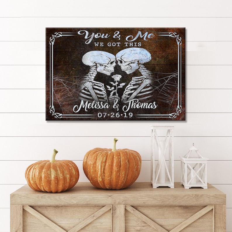 May include: A rustic wooden sign with a couple of skeletons holding a rose. The sign reads "You & Me We Got This Melissa & Thomas 07-26-19".