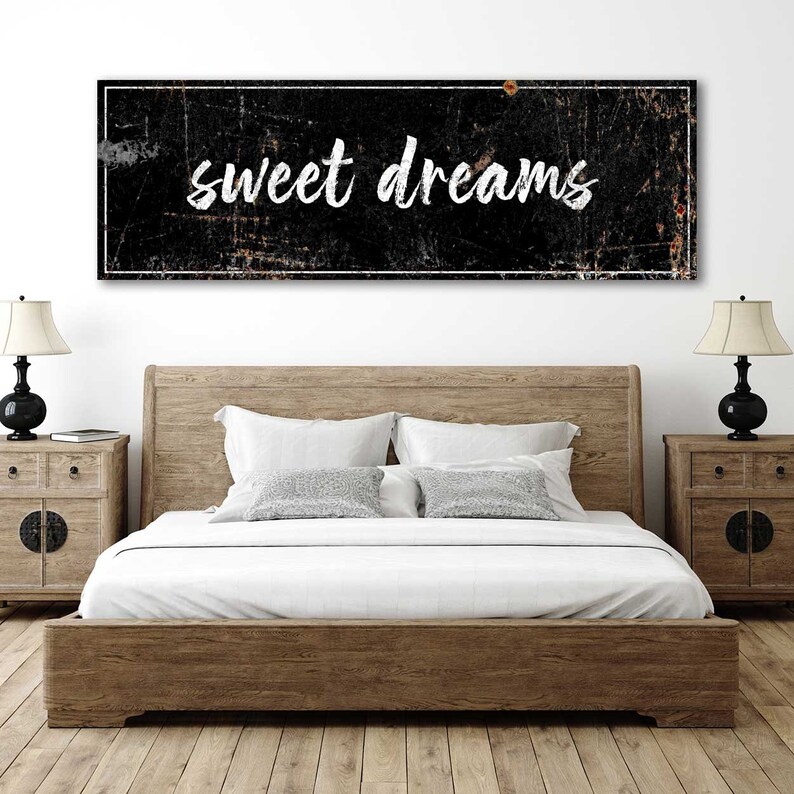 May include: Black and white rectangular sign with a distressed, vintage look. The sign has a white border and the words "sweet dreams" written in white cursive font.