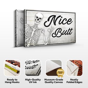 May include: A canvas wall art piece with a humorous design. The artwork features a black and white skeleton giving an "okay" hand gesture next to the words "Nice Butt" in a bold, black font. The background has a rustic, wood-like texture.