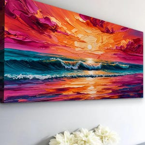 May include: A vibrant, textured canvas print depicting a sunset over the ocean. The artwork features a dynamic blend of colors, including shades of orange, pink, and blue, with visible brushstrokes creating a sense of movement and depth. The waves are crashing on the shore.