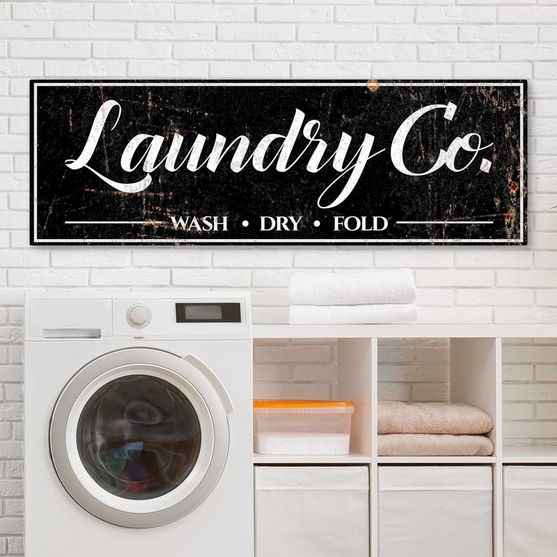 Laundry Service Co. Wash Dry Fold Personalized Laundry Room Decor of classic white script labels with vintage line embellishments on a rustic black canvas.