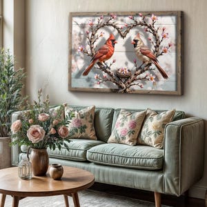 May include: A framed canvas print featuring a pair of red cardinals perched on a heart-shaped branch with pink blossoms. The cardinals are facing each other, and a small nest with eggs is visible in the center of the heart.