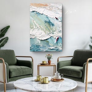 May include: Abstract ocean wave painting with textured brushstrokes in shades of blue, white, and beige. Two red figures are visible on the waves. The artwork is displayed on a white wall, above two green armchairs.