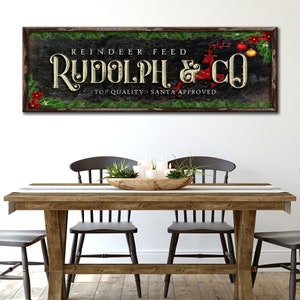 May include: A rustic wooden sign with green garland and red ornaments reads "Reindeer Feed Rudolph & Co. Top Quality - Santa Approved."
