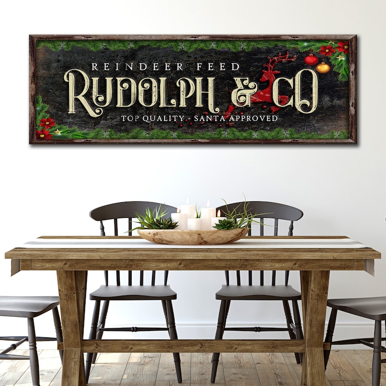 May include: A rustic wooden sign with green garland and red ornaments reads "Reindeer Feed Rudolph & Co. Top Quality - Santa Approved."