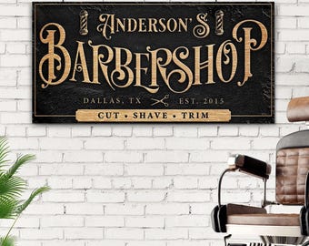 Może przedstawiać: Czarno-złoty szyld barberski z napisem "Anderson's Barbershop", "Dallas, TX", "Est. 2015" i "Cut - Shave - Trim".