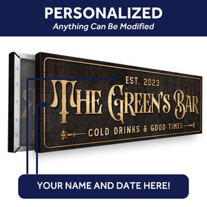 K&ouml;nnte beinhalten: Ein personalisiertes Holzschild mit dem Text "THE GREEN'S BAR" in goldenen Buchstaben. Das Schild enth&auml;lt auch den Text "EST. 2023" und "COLD DRINKS & GOOD TIMES" in kleineren goldenen Buchstaben. Das Schild hat einen dunklen Holzgrund und einen abgenutzten Look.