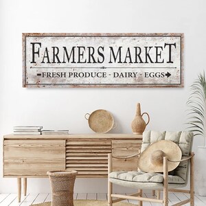 May include: A rustic wooden sign with the text "Farmers Market - Fresh Produce - Dairy - Eggs" in black lettering. The sign has a distressed white background and a brown border.