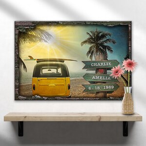May include: A yellow vintage van with a surfboard on top, parked on a beach with palm trees and a wooden sign that reads "Charlie Amelia 6-18-1989".