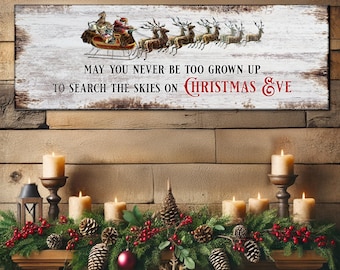 May include: A rectangular wooden sign with a distressed white background features Santa Claus in a sleigh pulled by reindeer. The text reads "MAY YOU NEVER BE TOO GROWN UP TO SEARCH THE SKIES ON CHRISTMAS EVE."