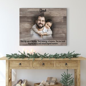Puede incluir: Una impresi&oacute;n de lienzo de madera con una foto de un padre y una hija abraz&aacute;ndose. El texto "Dad" est&aacute; en la parte superior de la impresi&oacute;n. El texto "Your life was a blessing. Your memory, a treasure. You are loved beyond words and missed beyond measure." est&aacute; en la parte inferior de la impresi&oacute;n.