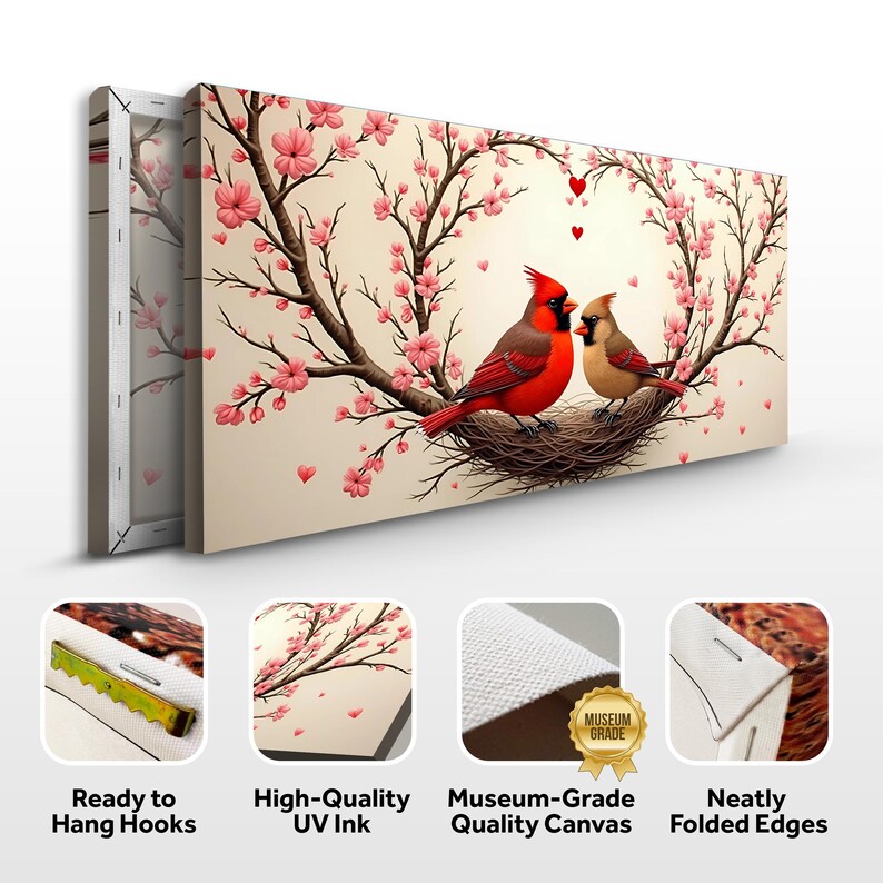 May include: Canvas wall art featuring a pair of red cardinals perched in a nest surrounded by pink cherry blossoms. The birds are looking at each other and there are small red hearts in the background. The canvas has a white border and is ready to hang with hooks.