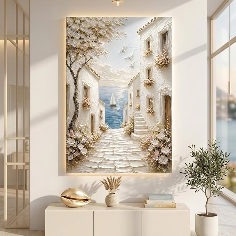 May include: A textured wall art piece depicting a Mediterranean coastal scene with white buildings, a stone path, blooming flowers, and a sailboat on the blue sea. The painting features thick impasto brushstrokes, white birds in the sky, and a tree.
