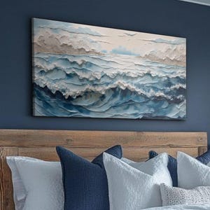 May include: A rectangular canvas art piece depicting an ocean scene. The artwork features textured waves in shades of blue and white, with a cloudy sky in the background. The painting is mounted on a dark blue wall above a bed.