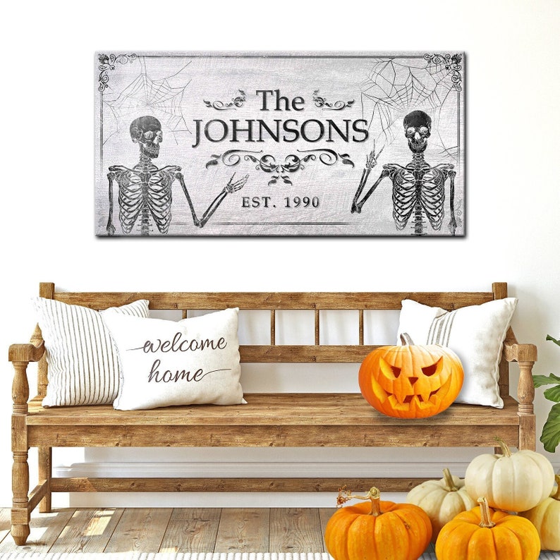 May include: A black and white Halloween-themed sign with two skeletons, a spiderweb, and the text "The JOHNSONS EST. 1990".