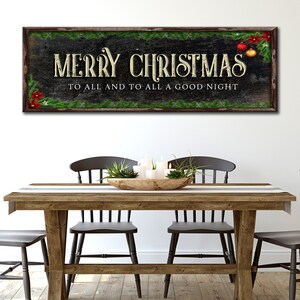 May include: A rustic wooden sign with a black background and green garland. The sign reads "Merry Christmas to all and to all a good night".