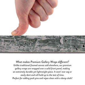 May include: A close-up of a canvas print wrapped over a solid front panel. A hand presses on the canvas to show its durability. The text reads: "What makes Premium Gallery Wraps different? Unlike traditional framed canvas sold elsewhere, our premium gallery wraps are wrapped over a solid front panel, making an extremely durable yet lightweight piece. It won't ever sag or easily dent and will hold up to the test of time. Perfect for adding push pins and wipes clean with a damp cloth!"