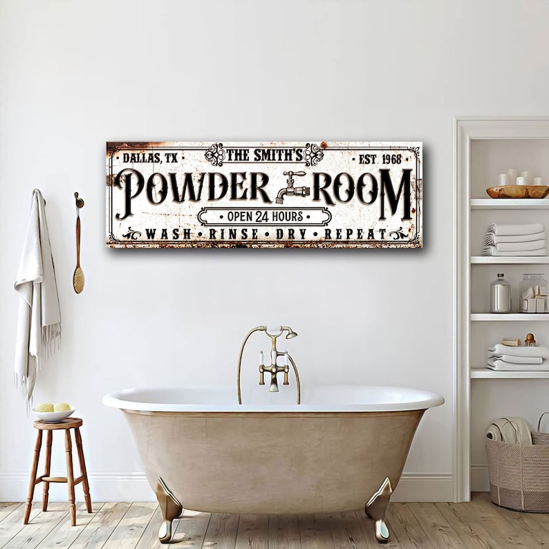 May include: A white vintage-style sign with black text that reads "DALLAS, TX. THE SMITH'S - EST. 1968. POWDER ROOM - OPEN 24 HOURS - WASH RINSE DRY REPEAT". The sign has a rusty, distressed look and features a faucet graphic.