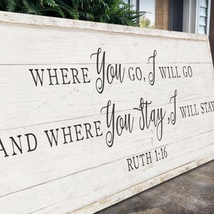 K&ouml;nnte beinhalten: Rechteckiges Holzschild mit wei&szlig;em Used-Look. Schwarze Schrift lautet: "WHERE YOU GO, I WILL GO AND WHERE YOU STAY, I WILL STAY" mit "RUTH 1:16" darunter. Das Schild besteht aus horizontalen Holzbrettern.