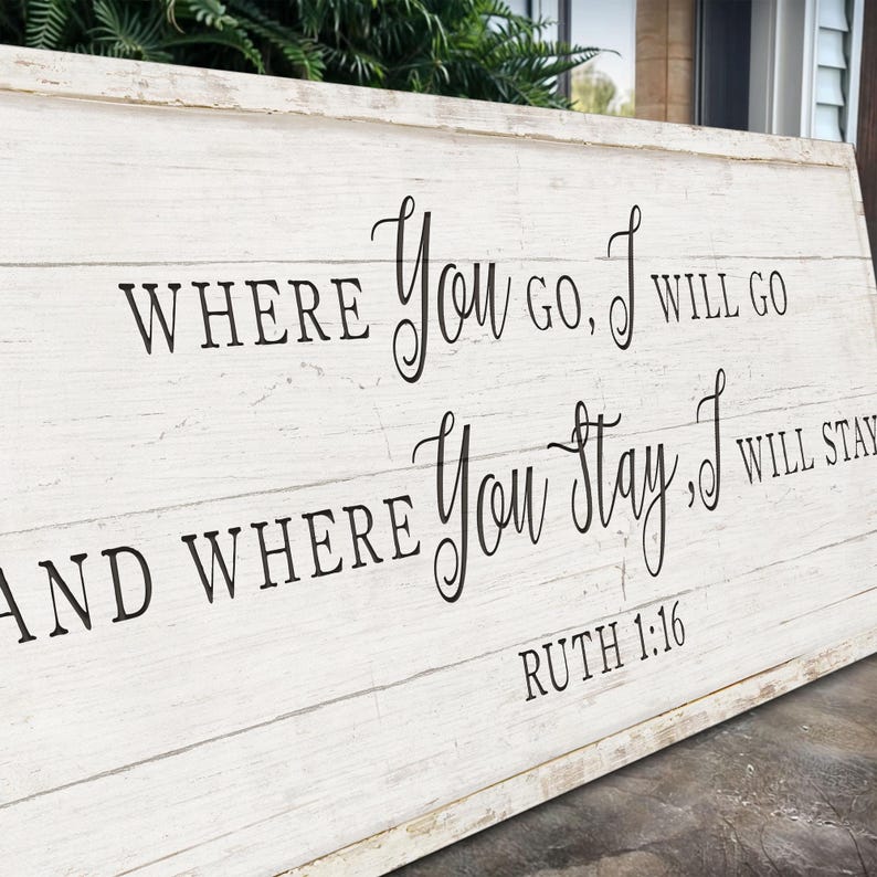 K&ouml;nnte beinhalten: Rechteckiges Holzschild mit wei&szlig;em Used-Look. Schwarze Schrift lautet: "WHERE YOU GO, I WILL GO AND WHERE YOU STAY, I WILL STAY" mit "RUTH 1:16" darunter. Das Schild besteht aus horizontalen Holzbrettern.