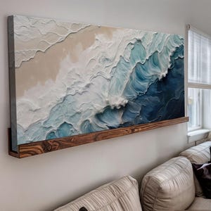 May include: Abstract painting of ocean waves in shades of blue and white, mounted on a wooden shelf.